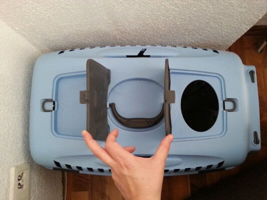 Two flaps on top of a cat carrier.